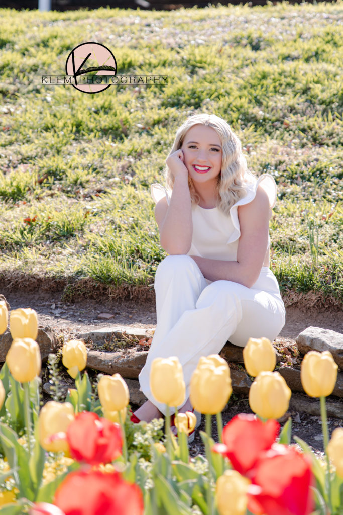 senior pictures in kentucky with senior girl sitting behind tulips