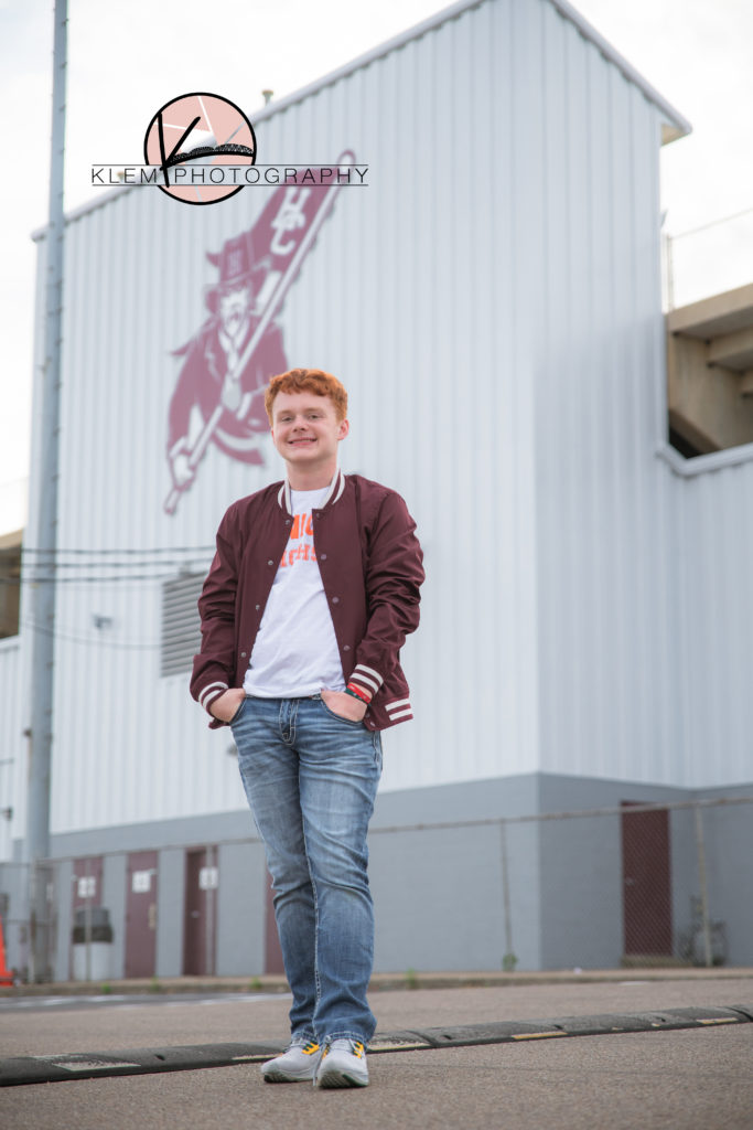 guy senior session in kentucky by klem photography kentucky senior photographer. guy is wearing white shirt and maroon track jacket  and jeans. He has wavy red hair