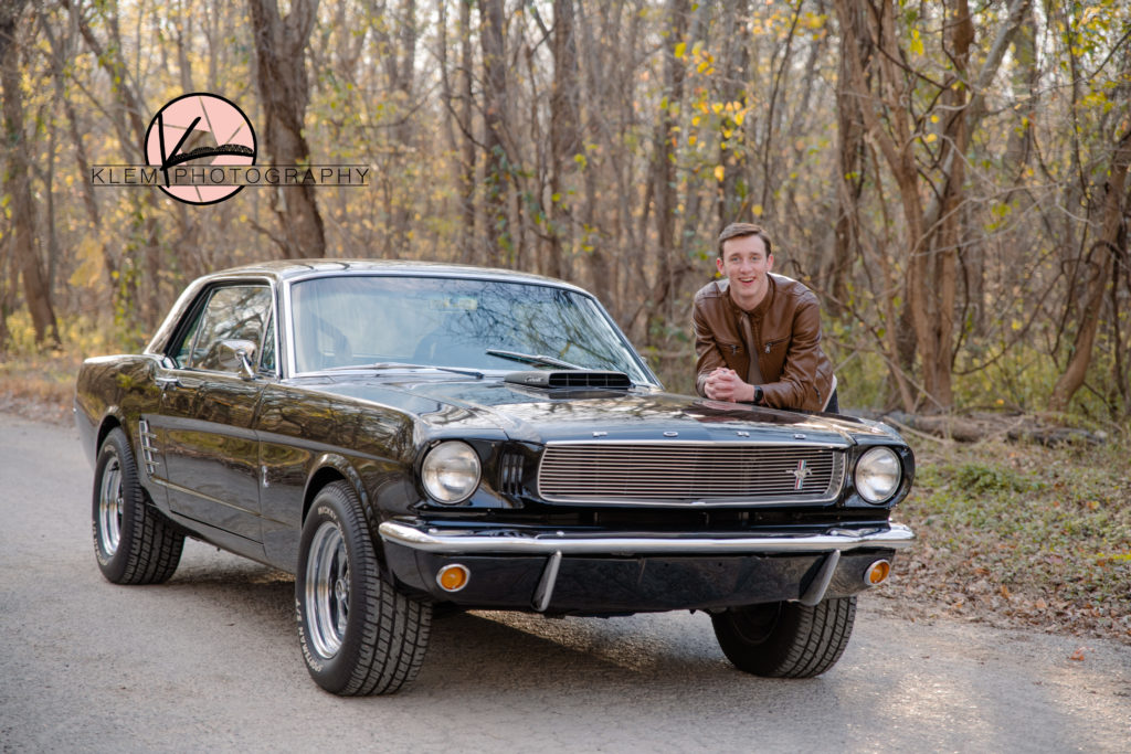 Senior Pictures Evansville IN senior guy stands next to his classic black mustang