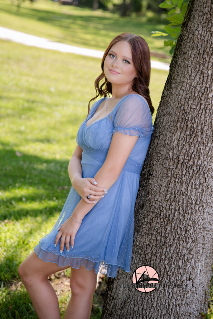 henderson ky high school senior wearing a purple dress and leaning her back against a tree