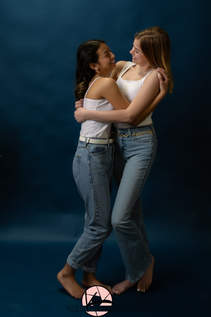 klem photography model team girls wearing white shirts with denim blue jeans with a solid navy backdrop taking the best senior pictures near me 