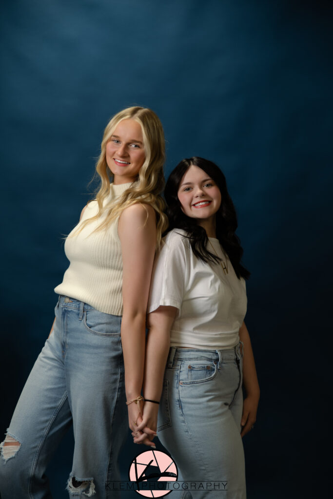 klem photography model team girls wearing white shirts with denim blue jeans with a solid navy backdrop taking the best senior pictures near me 