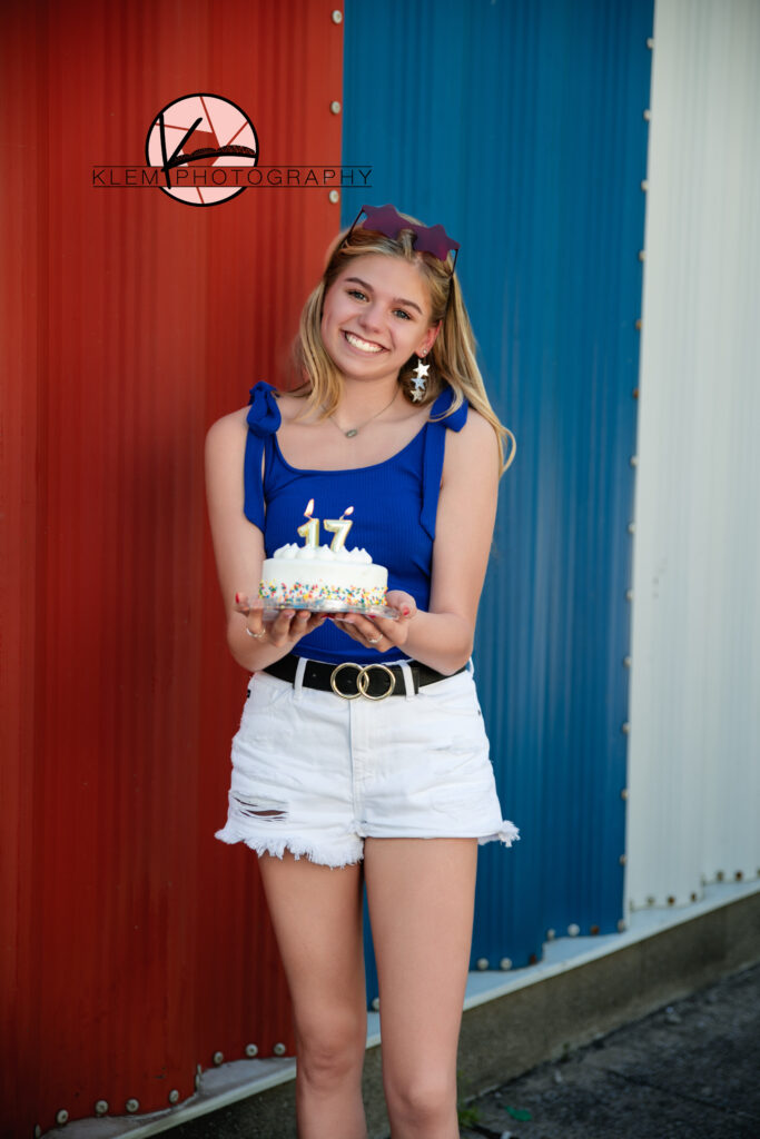 patriotic model team photos by evansville photographers with girl wearing patriotic themed clothing and holding a birthday cake